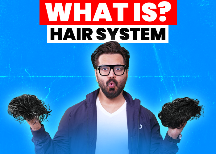 Man holding two hair systems in both hands, with the text 'What is? Hair System' displayed above. The background is bright blue, and the man appears surprised or intrigued, wearing glasses, a white shirt, and a blue jacket.